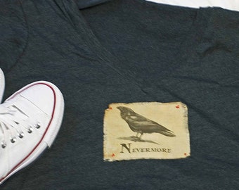 May include: A dark gray V-neck t-shirt with a vintage-style illustration of a raven and the text "Nevermore".