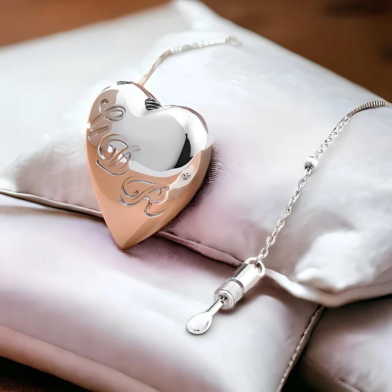 May include: A silver heart-shaped locket with a chain and a small silver spoon attached. The locket has the word "Love" engraved on it.