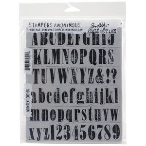 Puede incluir: Un conjunto de sellos de alfabeto y números con un diseño de texto desgastado. Los sellos son negros y blancos y están dispuestos en filas sobre un fondo blanco. El texto "STAMPERS ANONYMOUS" está en la parte superior de la imagen.