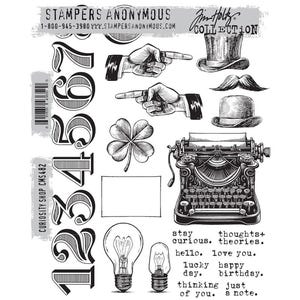 May include: A black and white stamp set featuring numbers, pointing hands, a top hat, a mustache, a bowler hat, a four-leaf clover, a typewriter, light bulbs, and text. The text includes phrases like "stay curious" and "hello love you."
