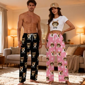 May include: Black pyjama trousers with a white drawstring and a repeating pattern of a cat face wearing a hat and the name Leroy, and pink pyjama trousers with a white drawstring and a repeating pattern of a cat face wearing a hat and white paw prints.