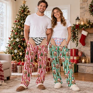 Puede incluir: Dos pantalones de pijama con temática navideña que presentan un patrón repetitivo de caras de golden retriever con gorros de Papá Noel, árboles de Navidad y calcetines. Un par tiene rayas rojas y blancas, el otro rayas verdes y blancas.