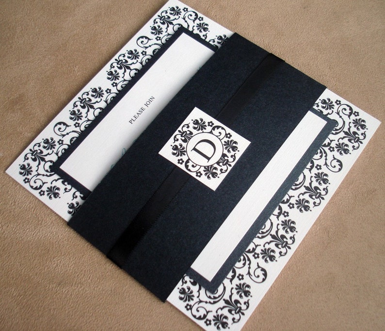 May include: Black and white wedding invitation with a black envelope and a decorative border. The invitation says "Please Join".