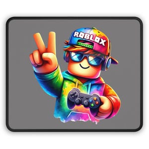 May include: A rectangular mouse pad with a gray background featuring a colorful character wearing a cap with the text ROBLOX, blue sunglasses, and headphones. The character is making a peace sign and holding a black game controller.