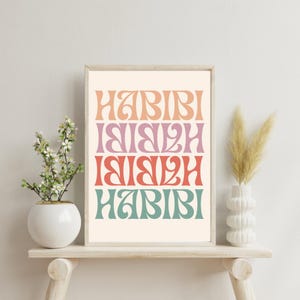 May include: A printable wall art print with the word "Habibi" repeated four times in a retro font. The word is in different colors, including peach, pink, red, and teal.