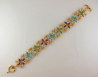 May include: A gold beaded bracelet with a heart-shaped clasp. The bracelet features a repeating pattern of small, colorful beads in shades of green, blue, and purple.