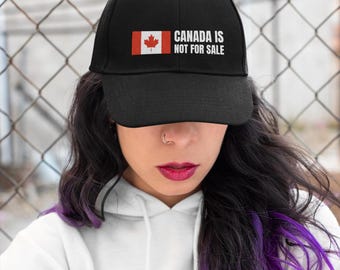 May include: A black baseball cap with a Canadian flag and the text "CANADA IS NOT FOR SALE" embroidered on the front.