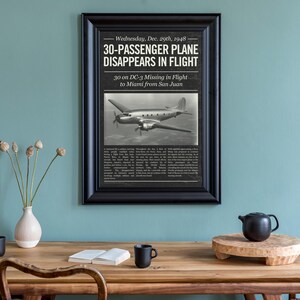 May include: A framed black and white print of a vintage newspaper article. The headline reads "30-PASSENGER PLANE DISAPPEARS IN FLIGHT." The article includes an image of a plane and text detailing the event. The frame is black.