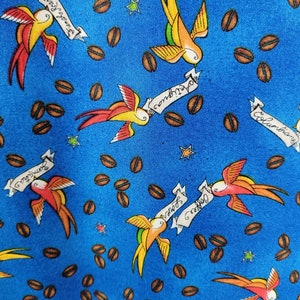 May include: A vibrant blue fabric featuring a repeating pattern of colorful swallows, coffee beans, and stars. The swallows are in shades of yellow, orange, and red, with banners that read "Coffee Lover", "Antigua", "Sumatra", and "Columbia".