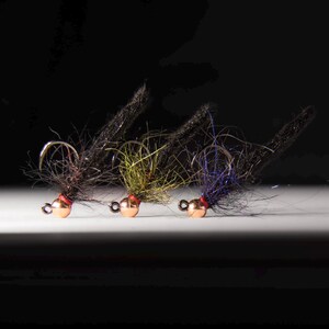 Puede incluir: Tres señuelos de pesca con mosca con cuentas de cobre y plumas negras, verdes y azules.