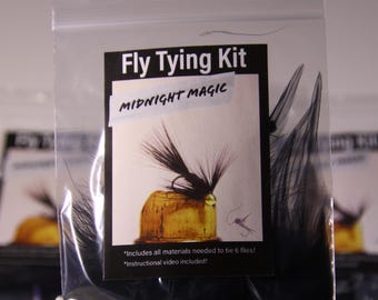 May include: A clear plastic bag containing a fly tying kit. The label reads "Fly Tying Kit" and "MIDNIGHT MAGIC". The kit includes materials to tie 6 flies and an instructional video.