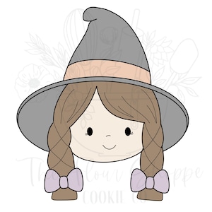 May include: A cookie cutter in the shape of a cartoon witch's face. The witch has brown braids, a gray witch hat with a peach-colored band, and lavender bows at the end of her braids. The face has a small smile.