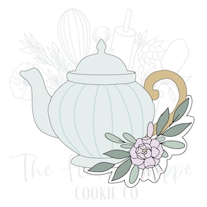May include: A light blue teapot cookie cutter with a gold handle and a floral arrangement. The teapot has a ribbed design and is decorated with a cluster of leaves and a light purple flower. The text "The Flour Shoppe Cookie Co" is at the bottom.