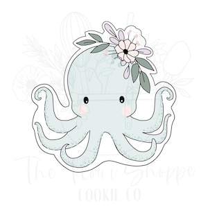 May include: A light blue octopus cookie cutter with a floral crown. The crown is made of pink and white flowers with green leaves.