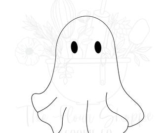 May include: A white ghost-shaped cookie cutter with two black oval eyes. The ghost has a simple, rounded design with a flowing bottom edge. The Flour Shoppe Cookie Co. is printed at the bottom.