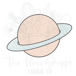 May include: A light pink cookie cutter shaped like a planet with a ring around it. The cookie cutter is outlined in black and the ring is light blue.