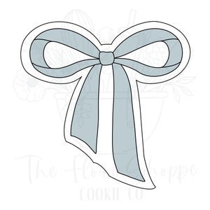 May include: A light blue bow-shaped cookie cutter with a white outline. The bow has two loops and two long, vertical streamers. The text "The Flower Shoppe Cookie Co" is at the bottom of the image.