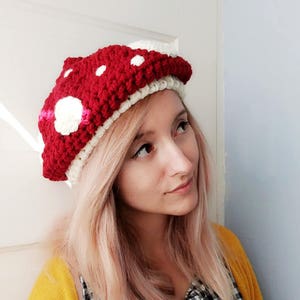 Peut inclure: Un chapeau en crochet en forme de champignon rouge et blanc avec des pois blancs.