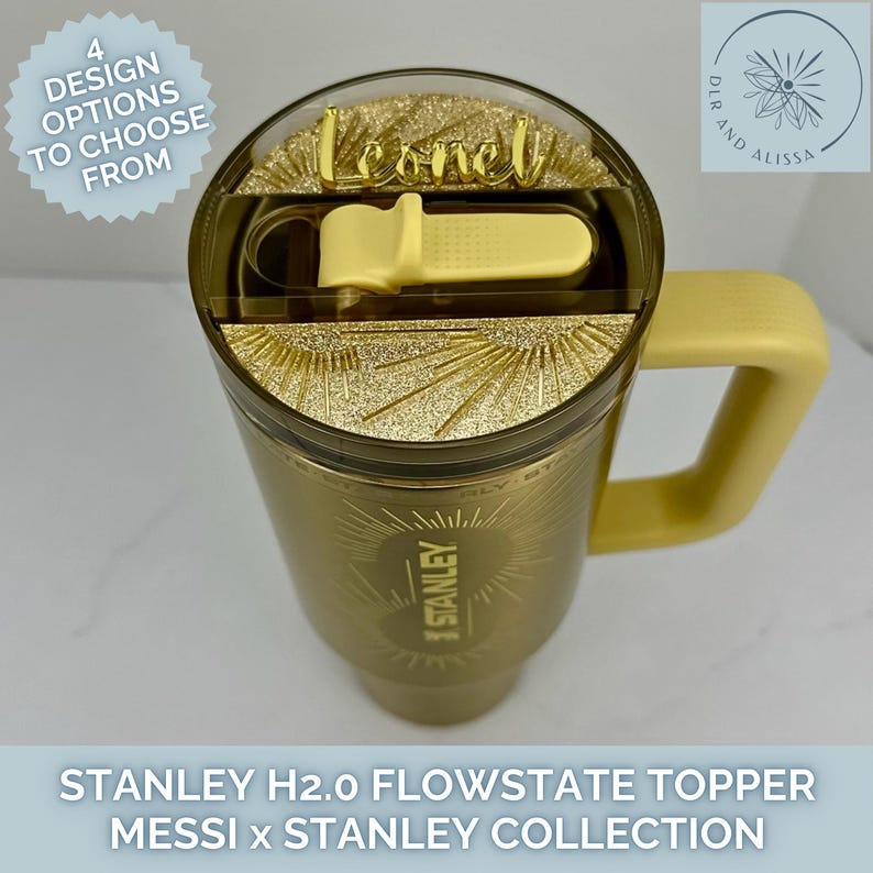 May include: A gold-coloured Stanley H2.0 FlowState tumbler featuring a matching gold handle and a lid with a yellow straw cover. The lid includes a gold glitter sunburst design and a custom gold name plate reading Leonel.