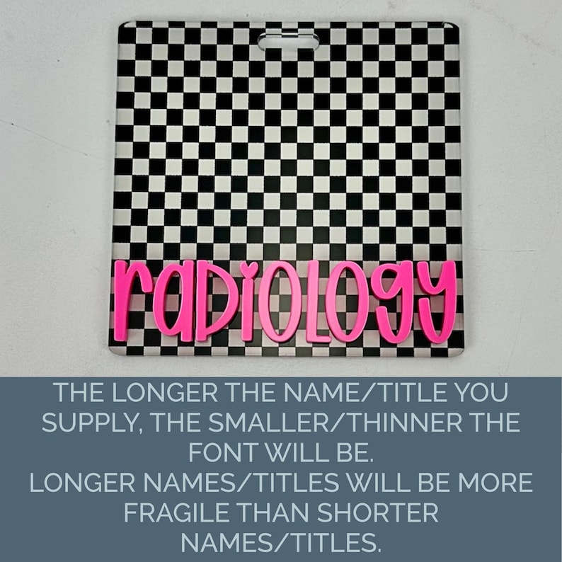 May include: A square badge reel featuring a black and white checkered pattern with the word radiology in bright pink, raised, cursive lettering. The top center of the badge has a horizontal slot for attachment, providing a clear, high-contrast design.