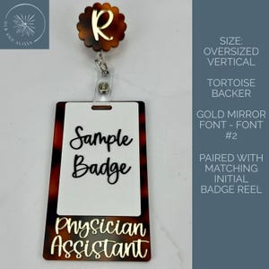 May include: An oversized vertical badge reel featuring a scalloped tortoise shell topper with a gold letter R. The rectangular badge holder has a white center, a tortoise shell border, black script text reading Sample Badge, and gold text Physician Assistant.