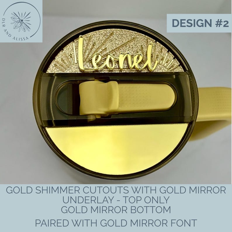 May include: A circular tumbler lid featuring a gold shimmer top section with the name Leonel in gold mirror script font. The lid includes a dark translucent sliding closure and a solid gold mirror bottom section. Text reads DESIGN #2.