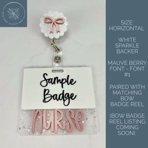 May include: A horizontal badge reel featuring a white sparkle backer and a mauve bow. The badge holder is white with the black text Sample Badge and the mauve text NURSE. The badge reel is attached to a circular white glitter piece with a mauve bow.