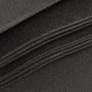 May include: Close-up of a black fabric with a textured weave. The fabric is folded in layers, showing the edges of each layer.