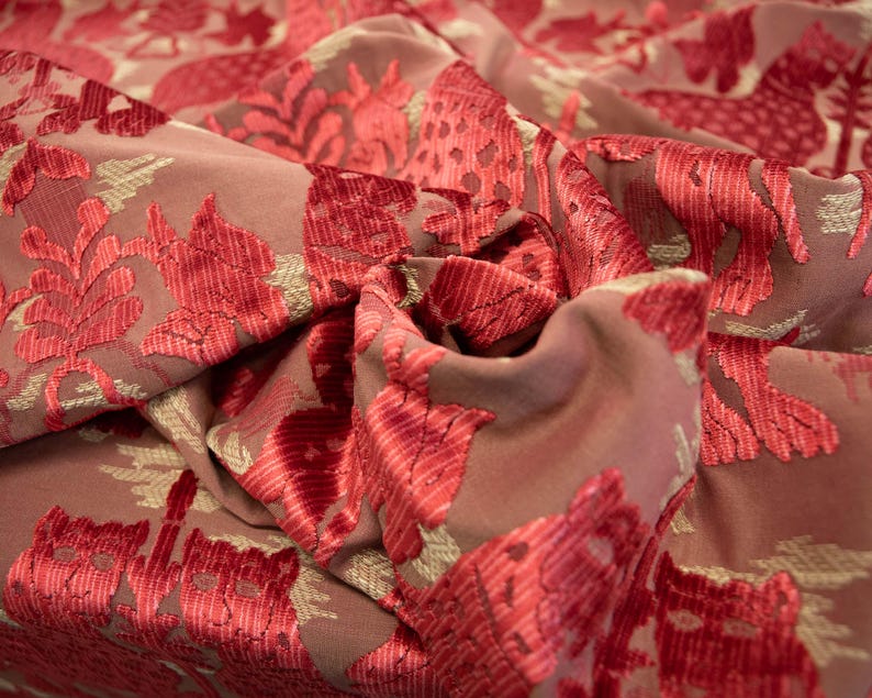 Pode incluir: Close-up de um tecido rosa com um padr&atilde;o floral vermelho. O tecido tem uma textura aveludada.