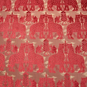 Pode incluir: Tecido vermelho com um padr&atilde;o repetido de elefantes estilizados. Os elefantes s&atilde;o delineados em um vermelho mais escuro e t&ecirc;m uma apar&ecirc;ncia texturizada.