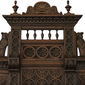 May include: A dark brown wooden headboard with intricate carvings. The headboard features a central crest with a shell design and two figures on either side. The headboard is ornate and detailed, with a variety of carvings and designs.