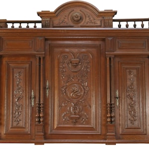 May include: A large, antique, wooden cabinet with three doors and intricate carvings. The cabinet is made of dark wood and has a rich, brown finish. The doors are all carved with floral designs and the top of the cabinet has a decorative, arched top.