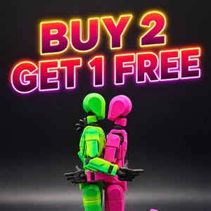 May include: Two articulated figures, one green and one pink, embrace against a black background. The figures are in a loving pose, with the text "BUY 2 GET 1 FREE" in neon colors above them. The figures are made of plastic.