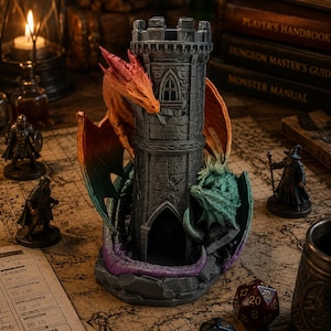 May include: A gray stone tower dice holder with a red and green dragon wrapped around it. The tower has a small arched window and is surrounded by miniature figurines, dice, and a map. The scene is lit by a candle and a lamp.