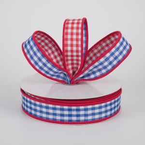 May include: A roll of decorative ribbon featuring a red, white, and blue gingham pattern. The ribbon is displayed in a bow shape, with the edges trimmed in red. The ribbon is perfect for crafts, gift wrapping, and holiday decorations.