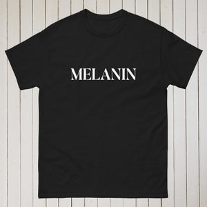 May include: Black t-shirt with the word "MELANIN" printed in white on the front.