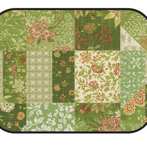 K&ouml;nnte beinhalten: Eine rechteckige Matte mit abgerundeten Ecken und schwarzem Rand, die ein Patchwork-Design aus verschiedenen gr&uuml;nen, wei&szlig;en und orangefarbenen Blumen- und Pflanzenmustern aufweist. Die Oberfl&auml;che zeigt ein Gitter aus Quadraten und Rechtecken.