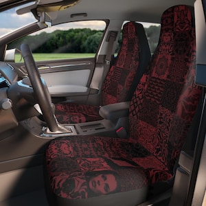 May include: A pair of car seat covers featuring a dark red and black patchwork design. The pattern consists of repeating squares displaying various gothic-inspired motifs, including intricate floral filigree, ornate scrollwork, and human faces.