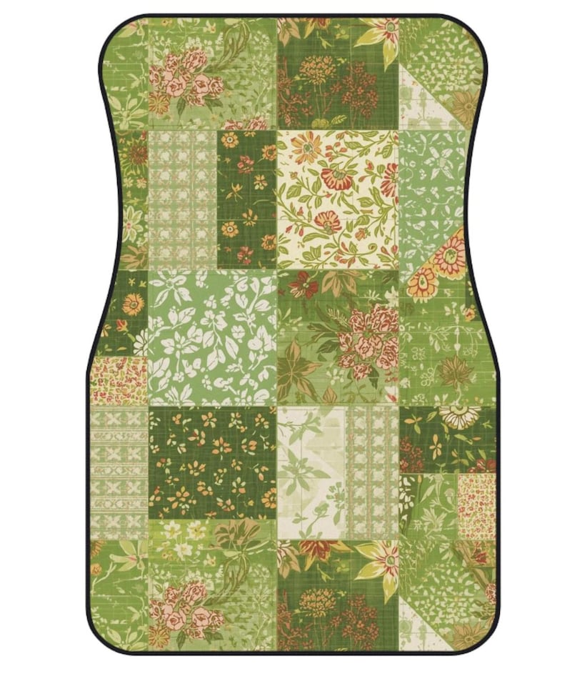 K&ouml;nnte beinhalten: Eine rechteckige Fu&szlig;matte mit abgerundeten oberen Ecken und schwarzem Rand, die ein Patchwork-Design aus verschiedenen gr&uuml;nen und cremefarbenen Blumenmustern aufweist, einschlie&szlig;lich botanischer Illustrationen von Bl&auml;ttern und Bl&uuml;ten.