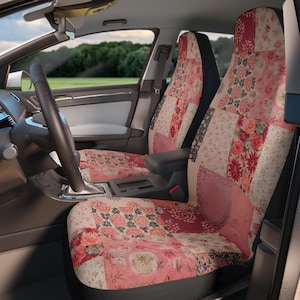 May include: A pair of car seat covers featuring a patchwork design in various shades of pink, red, and cream. The pattern consists of multiple squares displaying floral motifs, intricate botanical illustrations, and solid textured fabric sections.