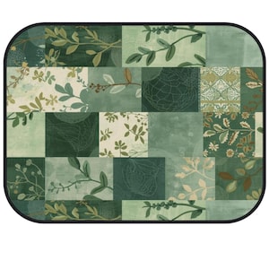 May include: A rectangular mat with rounded corners and a black border, featuring a patchwork design of various shades of green. The pattern includes botanical illustrations of leaves, branches, and floral motifs mixed with solid and textured blocks.