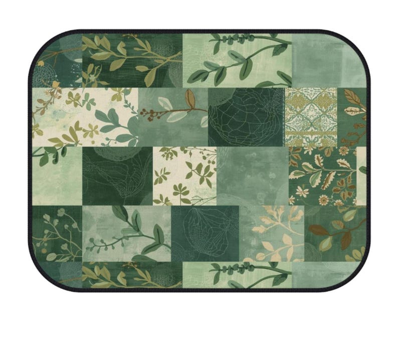May include: A rectangular mat with rounded corners and a black border, featuring a patchwork design of various shades of green. The pattern includes botanical illustrations of leaves, branches, and floral motifs mixed with solid and textured blocks.