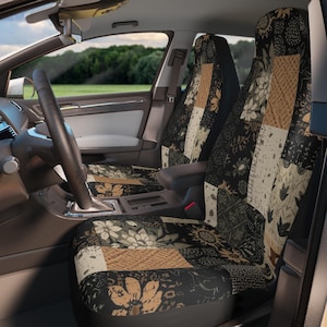May include: Car seat covers with a patchwork design. The covers feature a mix of floral and geometric patterns in black, beige, and brown. The interior of the car is visible, including the steering wheel and dashboard.