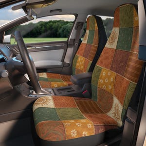 Puede incluir: Fundas de asiento de coche con diseño de patchwork. Las fundas presentan cuadrados de varios colores y patrones, incluyendo motivos florales, solares y geométricos. La paleta de colores incluye tonos de marrón, verde y amarillo, creando una estética rústica.