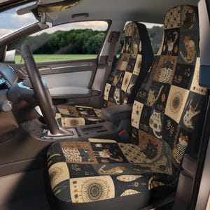 May include: Car seat covers with a patchwork design featuring various cat illustrations in shades of brown, beige, and black. The covers are installed in a car, with the steering wheel and dashboard visible.