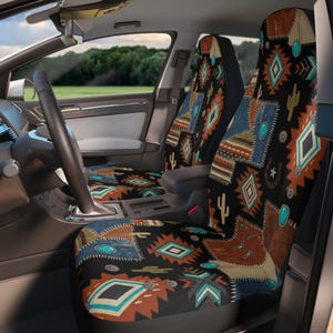 May include: A pair of car seat covers featuring a patchwork design with black, brown, blue, and turquoise geometric patterns, cactus silhouettes, and horseshoe motifs. The fabric displays a mix of denim, leather, and woven textures throughout.