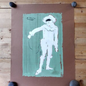 May include: A brown paper poster with a green background featuring a white silhouette of a clown with a hat. The poster is signed "Picasso" in the top left corner.