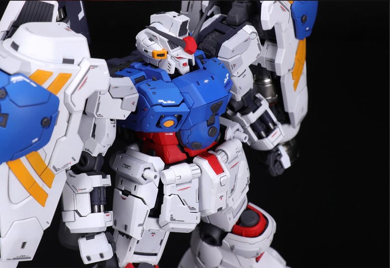 Puede incluir: Modelo detallado de robot con esquema de color blanco, azul, rojo y amarillo. El robot tiene un dise&ntilde;o complejo con m&uacute;ltiples partes articuladas, incluyendo cabeza, torso, brazos y piernas. El modelo est&aacute; sobre un fondo negro.