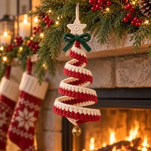 May include: A spiral-shaped Christmas tree ornament made of crocheted yarn in alternating red and cream stripes. The ornament features a cream-colored crocheted star at the top, a dark green crocheted bow, and a small gold-toned metal bell at the base.