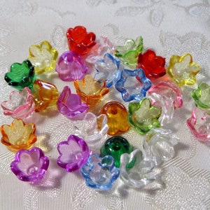 May include: Assortment of colorful plastic flower-shaped beads in various colors, including red, yellow, green, blue, and pink. The beads are translucent and have a glossy finish.